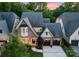 Stunning aerial view of a brick home with a three-car garage, manicured lawn, and lush landscaping in a serene setting at 4635 Harper Ct, Charlotte, NC 28210
