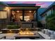 Relaxing outdoor space with cozy seating around a stone fire pit, featuring ambient lighting and a covered patio above at 4635 Harper Ct, Charlotte, NC 28210