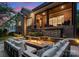 Serene patio area with comfortable seating around a stone fire pit, set amongst lush landscaping and ambient lighting at 4635 Harper Ct, Charlotte, NC 28210
