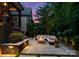 Inviting backyard patio with stone fire pit, ample seating, lush greenery, and ambient lighting for relaxing evenings at 4635 Harper Ct, Charlotte, NC 28210