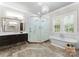 Luxurious bathroom with a soaking tub, glass shower, double vanity, and elegant fixtures at 4635 Harper Ct, Charlotte, NC 28210