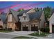 Elegant brick home with three-car garage, lush lawn, and tasteful landscaping against a vibrant sunset backdrop at 4635 Harper Ct, Charlotte, NC 28210