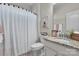 Bathroom featuring a toilet, tub with a white curtain, granite countertop, mirror, lighting, and decorative artwork at 5104 Samoa Ridge Dr, Lancaster, SC 29720