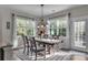 Bright dining room with large windows, an elegant chandelier, and a beautifully set table for Gathering gatherings at 5104 Samoa Ridge Dr, Lancaster, SC 29720