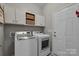 A well-organized laundry room with overhead cabinets and modern washer and dryer set for efficient chore management at 5104 Samoa Ridge Dr, Lancaster, SC 29720
