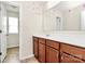 Bathroom with wood cabinets, mirror, and door to the lavatory at 5146 Elementary View Dr, Charlotte, NC 28269