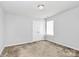 A bright neutral-colored bedroom featuring carpeted floors and a double door closet at 5146 Elementary View Dr, Charlotte, NC 28269