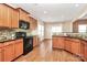 Well-equipped kitchen featuring wood cabinetry, granite countertops, and a mosaic tile backsplash for a stylish look at 5146 Elementary View Dr, Charlotte, NC 28269