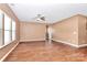 A spacious open living room features hardwood floors, and natural light from the three horizontal windows at 5146 Elementary View Dr, Charlotte, NC 28269