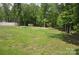 Serene backyard with mature trees, white fence, lush lawn, and natural surroundings, perfect for recreation at 5817 Wingate Hill Rd, Denver, NC 28037