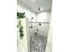 Modern bathroom shower featuring white marble tile, hexagon floor, and neutral accent stripe at 5817 Wingate Hill Rd, Denver, NC 28037