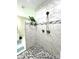 Modern bathroom shower featuring white marble tile and neutral accent stripe and hexagon floor at 5817 Wingate Hill Rd, Denver, NC 28037