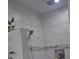 Bright shower with marble-patterned tile, decorative accent border, and convenient recessed shelving for toiletries at 5817 Wingate Hill Rd, Denver, NC 28037