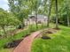 Beautiful backyard with a red brick pathway and lake access and views, surrounded by mature trees at 5951 Johnson Rd, Clover, SC 29710