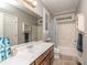Bathroom with shaker cabinets, white countertops, large mirror, and a bathtub with shower and blue shower curtain at 5951 Johnson Rd, Clover, SC 29710