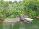 Charming lakefront property featuring a wooden dock, lush greenery and waterfront access at 5951 Johnson Rd, Clover, SC 29710