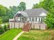 Exterior of home with brick stairs, deck with seating, white railing, and a green lawn at 5951 Johnson Rd, Clover, SC 29710