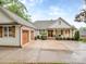Charming home features a two-car garage, lush lawn, and inviting front porch with wooden columns and cozy seating at 5951 Johnson Rd, Clover, SC 29710