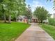 Charming home features a two-car garage, lush lawn, and inviting front porch with wooden columns and cozy seating at 5951 Johnson Rd, Clover, SC 29710
