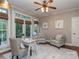 Bright office space with neutral walls, ceiling fan, and a light wood desk situated in front of a window to the balcony at 5951 Johnson Rd, Clover, SC 29710