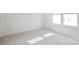 Empty bedroom featuring neutral carpet, white walls, baseboard trim, and a bright window at 6005 Countess Dr # 49, Charlotte, NC 28217