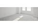 Empty bedroom featuring neutral carpet, white walls, baseboard trim, and a bright window at 6005 Countess Dr # 49, Charlotte, NC 28217