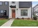 Stylish townhome exterior with brick, modern black accents, and a welcoming front door with green wreath at 6005 Countess Dr # 49, Charlotte, NC 28217