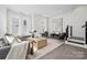 Open-concept living room with modern decor, large windows, comfortable seating, and staircase at 6005 Countess Dr # 49, Charlotte, NC 28217