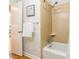 Bathroom with a shower-over-tub, tiled surround, and neutral walls with a bird-themed art piece at 6338 Rosecrest Dr, Charlotte, NC 28210