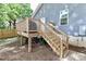 View of the wooden deck with stairs, and a large yard with lush green foliage at 703 S Main St, Landis, NC 28088