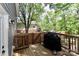 View of the wooden deck overlooking a large backyard and mature trees, with privacy fence at 703 S Main St, Landis, NC 28088