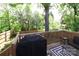 View of the spacious wood deck with a grill, surrounded by lush greenery and mature trees at 703 S Main St, Landis, NC 28088