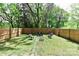 Serene backyard features a fire pit seating area, surrounded by a privacy fence and lush greenery, perfect for relaxing at 703 S Main St, Landis, NC 28088