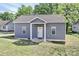 Charming house features gray siding, a covered porch, and lush green lawn in a residential neighborhood at 703 S Main St, Landis, NC 28088