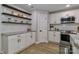 Kitchen featuring white subway tile, granite countertops, stainless steel appliances, and wood floating shelves at 703 S Main St, Landis, NC 28088