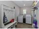 Bright laundry room features modern washer and dryer with built-in storage and functional storage shelves at 703 S Main St, Landis, NC 28088