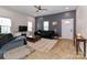 Inviting living room with neutral walls, ceiling fan, and windows, with an area rug and dark sofas at 703 S Main St, Landis, NC 28088