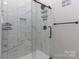 Modern walk-in shower with white tile and decorative shelving at 703 S Main St, Landis, NC 28088