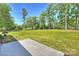 View of spacious backyard with lush lawn, mature trees and an outside patio at 7768 Lynwood Ln, Sherrills Ford, NC 28673