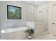 Bright bathroom featuring a soaking tub, walk-in shower, and marble surround at 7768 Lynwood Ln, Sherrills Ford, NC 28673