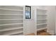 Spacious walk-in closet featuring white shelving units and a window offering natural light at 7768 Lynwood Ln, Sherrills Ford, NC 28673