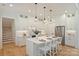 Modern white kitchen featuring a center island with seating, stainless steel appliances, and stylish pendant lighting at 7768 Lynwood Ln, Sherrills Ford, NC 28673