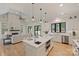 Open kitchen with island and seating, seamlessly blending into living area with fireplace and outdoor access at 7768 Lynwood Ln, Sherrills Ford, NC 28673