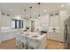 Bright kitchen with a large island, white cabinetry, stainless steel appliances, and elegant pendant lights at 7768 Lynwood Ln, Sherrills Ford, NC 28673