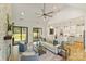 Open-concept living room showcasing hardwood floors, a ceiling fan, and seamless flow into the modern, white kitchen at 7768 Lynwood Ln, Sherrills Ford, NC 28673