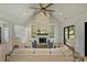 Bright living room featuring a stone fireplace, built-in shelves, ceiling fan, and sliding glass doors to the outside at 7768 Lynwood Ln, Sherrills Ford, NC 28673