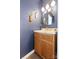 Stylish powder room features dark blue walls, wood vanity, and decorative gold fixtures at 8901 Powder Works Dr, Huntersville, NC 28078