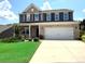 Two-story brick home featuring a two-car garage, manicured lawn and a welcoming front porch at 8901 Powder Works Dr, Huntersville, NC 28078