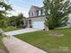 Charming two-story home with a brick facade, a well-manicured lawn, and an attached two-car garage at 8901 Powder Works Dr, Huntersville, NC 28078