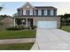 Beautiful two-story home with brick and siding, a well-manicured lawn, and an attached two-car garage at 8901 Powder Works Dr, Huntersville, NC 28078